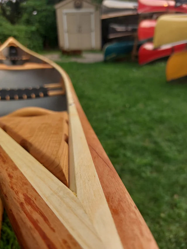 Discounted Rheaume Prospector 16.6 Kevlar Canoe with Wood Trim:  With a 35-year legacy of crafting canoes in Quebec, Canada, the Rheaume Prospector 16’6” stands as a testament to versatile and responsive design, beloved by paddlers of all skill levels.